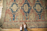 Geometric border and worn pile of antique Caucasian Soumac rug, red, navy, ivory, feet for scale.