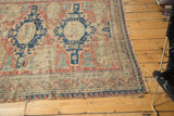 Tattered side border with geometric madder red and navy patterns of the antique Soumac rug.