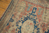 Worn texture of the antique Soumac rug, highlighting madder red and navy geometric motifs.