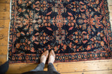 Traditional Lilihan rug corner: floral palmettes, indigo field, secured fringe, and pile wear.