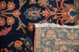 Lilihan rug corner showing indigo floral pile, white fringe, and hand-knotted foundation.