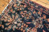 Vintage Lilihan rug detail showing indigo field, floral blossoms, saffron yellow, bronze motifs, and wear.