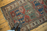 Hard tatter, madder red, and sea foam green geometric patterns on an antique Caucasian rug.