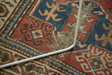 Hard tatter and geometric rams horn guls on an antique Caucasian rug.