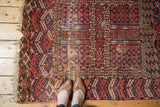 Antique Turkmen rug detail with cochineal red and navy geometric animal motifs.