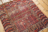 Antique Turkmen rug corner shows geometric animal motifs, serrated borders, and worn fringe.