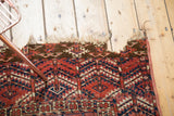 Tattered fringe and large perimeter hole on an antique Turkmen rug's corner.