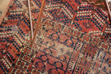 Geometric madder red, navy, ivory patterns on antique Turkmen rug with perimeter tatter.