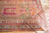 Corner detail of antique Mudjur rug with worn magenta field and pistachio green borders.