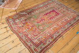 Antique Mudjur prayer rug border: magenta, pistachio, tangerine patterns, and exposed foundation.