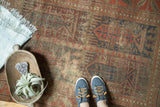 Antique Belouch rug detail: indigo blue, pomegranate red tree-of-life motif, and visible foundation.