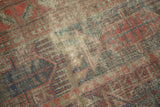 Allover wear and exposed foundation on an Antique Belouch rug, with muted motifs.