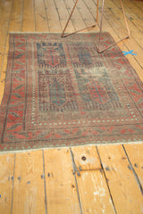 Visible secured fringe and areas of restrung foundation showing through an antique Belouch rug.