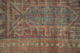 Antique Belouch rug detail: geometric tree-of-life motif, indigo, red, and visible foundation.