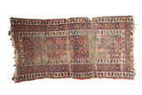 Fragmented vintage Caucasian runner, madder red and navy geometric medallions with flowers, heavily worn.