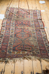Fragmented vintage Caucasian runner with heavily worn pile, exposed foundation, and frayed fringe.