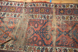 Visible hard tatter and foundation on vintage Caucasian rug runner with red and blue patterns.