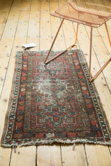 Vintage Karaja rug showing geometric contours, worn pile texture, multi-color selvage, tattered fringe.