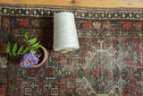 Vintage Karaja rug detail: hand-knotted geometric pattern in cherry red, mallard green, ivory.