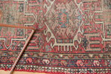 Dusty black cherry and navy border with tattered red fringe on vintage Karaja rug.