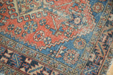Heriz rug's terra cotta and sapphire blue field with hook and latch motif.