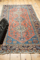 Tattered fringe and hook-and-latch border with geometric field on a vintage Heriz runner.