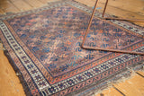 Antique Persian Belouch rug with rich aubergine field, blue geometric lattice, patterned border.