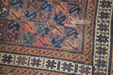 Detail of visible tatter on aubergine geometric antique Belouch rug.