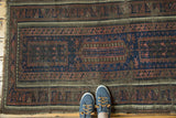 Antique Belouch runner's indigo blue field and distinct Laleh Abbasi borders, showing aged texture.