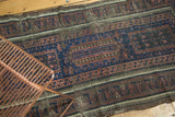 Indigo field with Laleh Abbasi geometric borders and tattered edge of an antique Belouch runner.