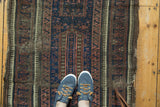 Antique Persian Belouch runner showcases indigo blue, aubergine, ivory, and charcoal geometric patterns.