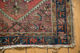 Vintage Mehriban rug corner with deep navy border, contrasting red field, and aged fringe.