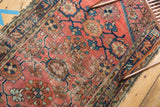 Vintage Mehriban runner corner: brick red Mina Khani pattern, navy border, and tattered edge.