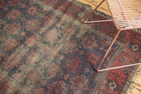 Worn field of an antique Belouch rug with indigo blue, red, and faded floral motifs.
