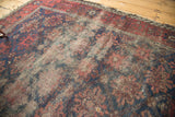 Heavily worn indigo and wine red floral antique Belouch rug, exposed foundation.