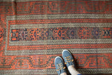 Hand knotted antique Belouch runner's wide banded borders and geometric patterns with etched tones.