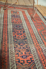 Textural antique Belouch runner detail, displaying geometric patterns within red and earth-toned bands.