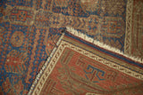 Folded antique Timuri Belouch rug, showing hand-knotted texture, fringe, and muted geometric motifs.