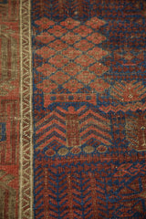 Abrashed geometric garden motifs in pomegranate red and cobalt blue with charcoal border.