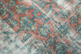 Textured pile of a vintage Mahal showing blush, sea foam, and ivory floral vinery.