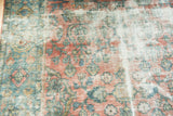 Vintage Mahal carpet showing hard distress, faded reds, blues, and visible foundation.