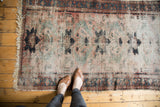 Exposed foundation showing faded dusty rose, teal, and charcoal patterns on Persian Lilihan rug.