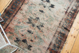 Vintage Persian Lilihan rug's well-worn texture, exposed foundation, dusty rose, and faded teal.