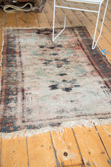 Vintage Lilihan rug showing tattered white fringe and exposed foundation with faded rose and teal tones.