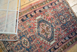 Vintage Karaja rug detail: serrated main medallion, hook and latch, pinwheel motifs on blush cinnabar field.