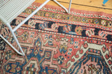 Visible knot heads, serrated hook and latch motifs, and abrashed blush red field of a vintage Karaja.