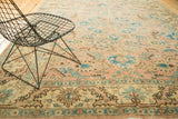 Vintage Tabriz rug detail showing curvilinear palmettes, lotus flowers, and vinery in peach and blue tones.