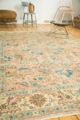 Vintage Tabriz rug close-up: peach, ivory, sky blue floral palmettes and vinery.