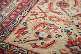 Close detail: vintage Malayer rug's pale saffron field with repeating red, navy Herati motif.