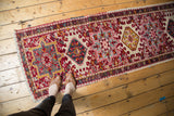 Vintage Persian Karaja runner with geometric medallions in cherry red, ivory, and vibrant accents.